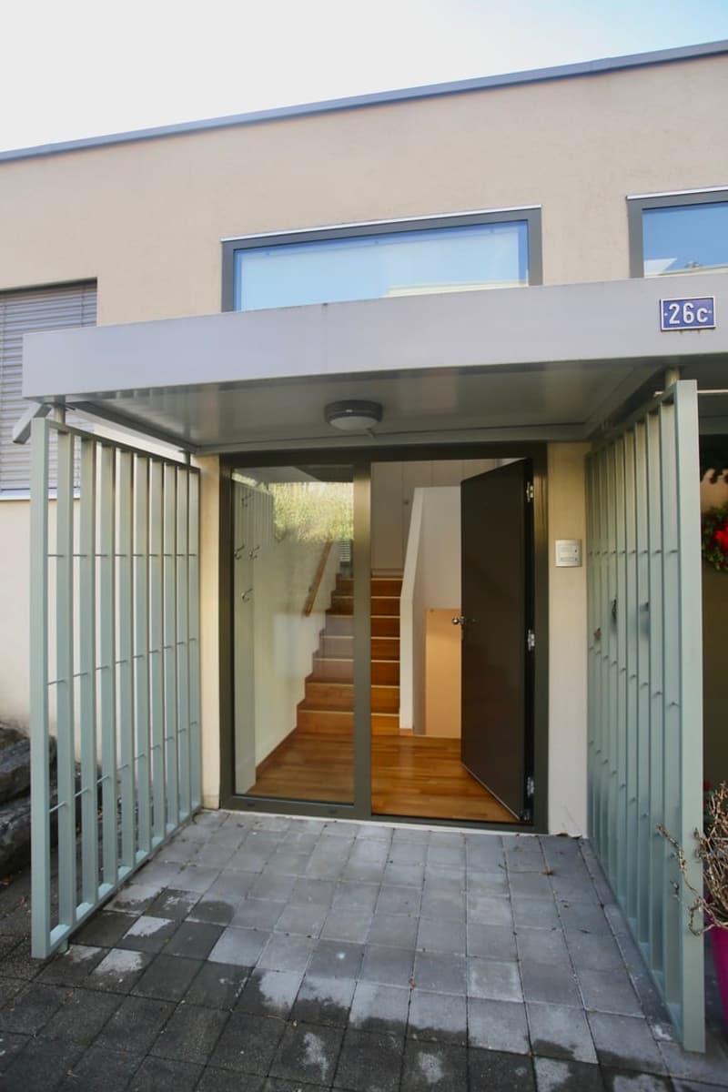 entrance with steel gates, glass door, wooden stairs, paved entrance