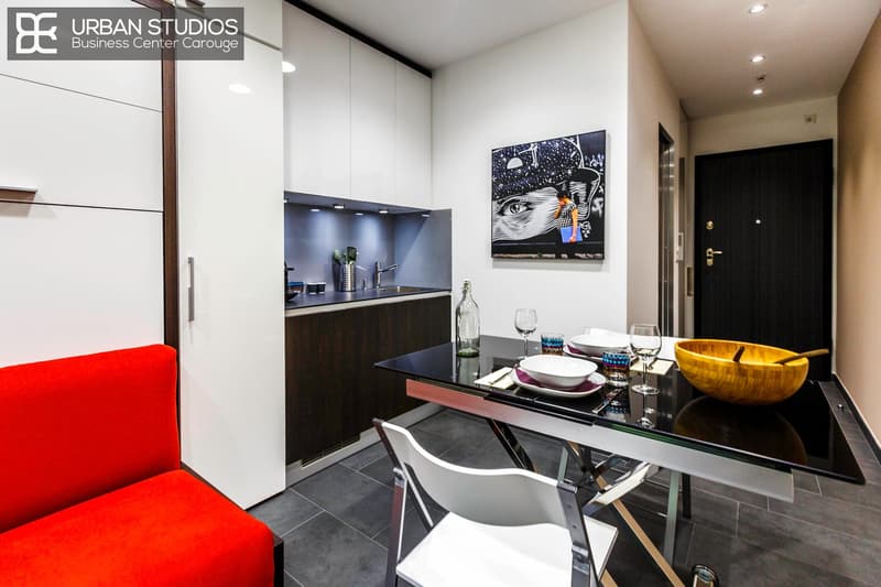 minimalist kitchen with modern furniture, dining table with bowls and wine glasses, white chairs, and a white cabinet
