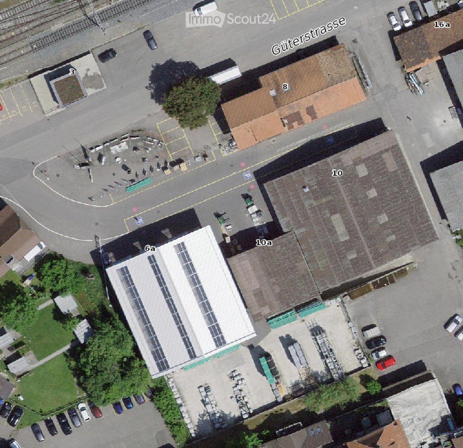 Multiple buildings and a lot of cars parked on an aerial view of the street.