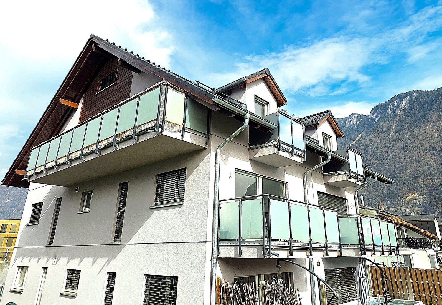 3 story house, white exterior, brown roof, multiple balconies, mountain view