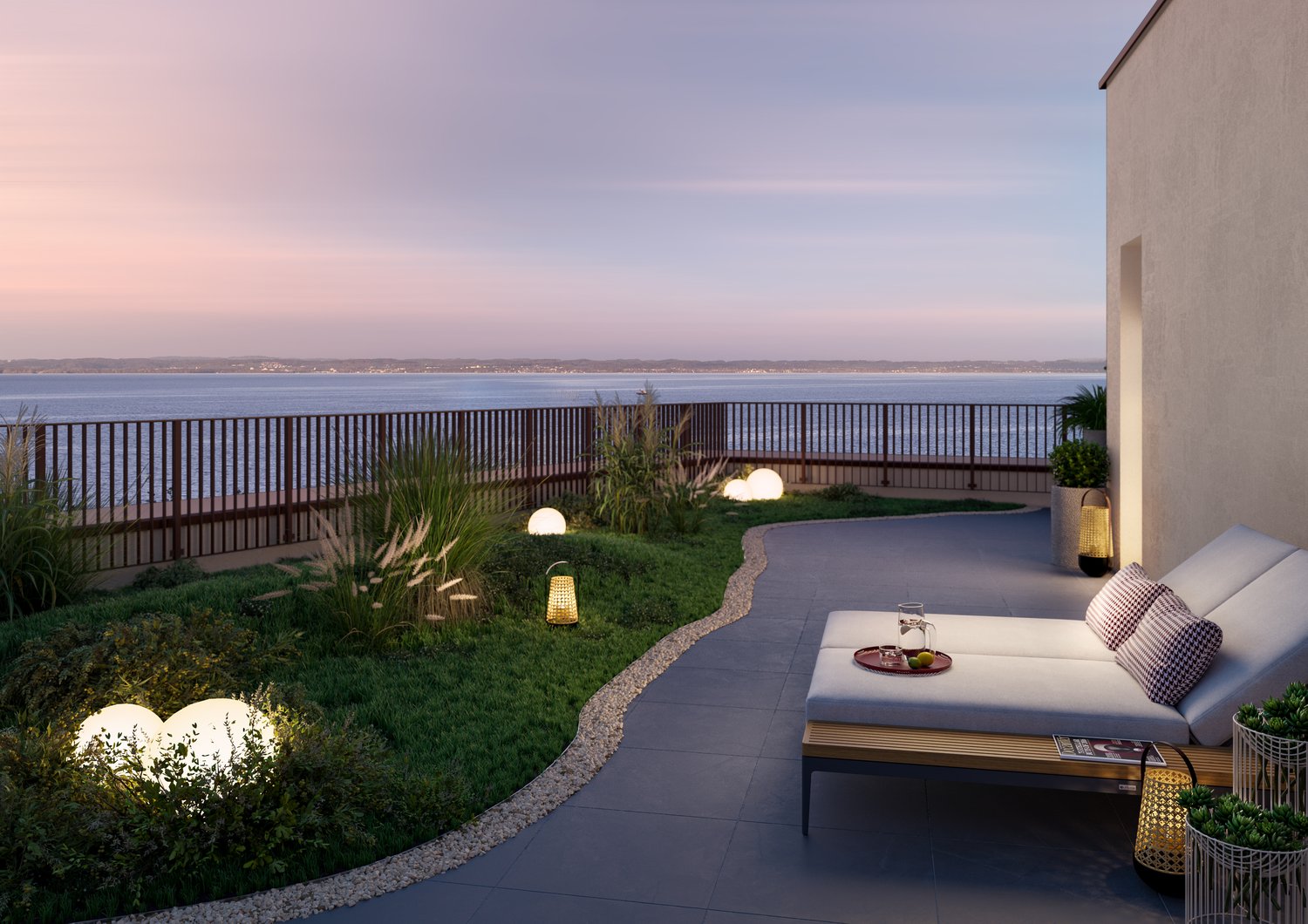 Outdoor lounge area with couch, decorative lamps, grass, and sea view.