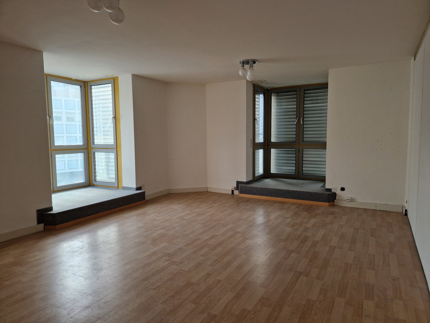 empty room, wooden floor, large windows, white walls, ceiling lights