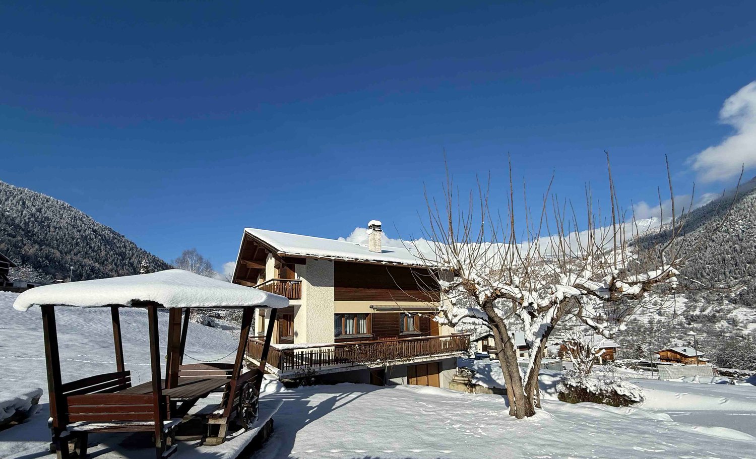 Mountain chalet with terrace, snow-covered, snowy mountains in background