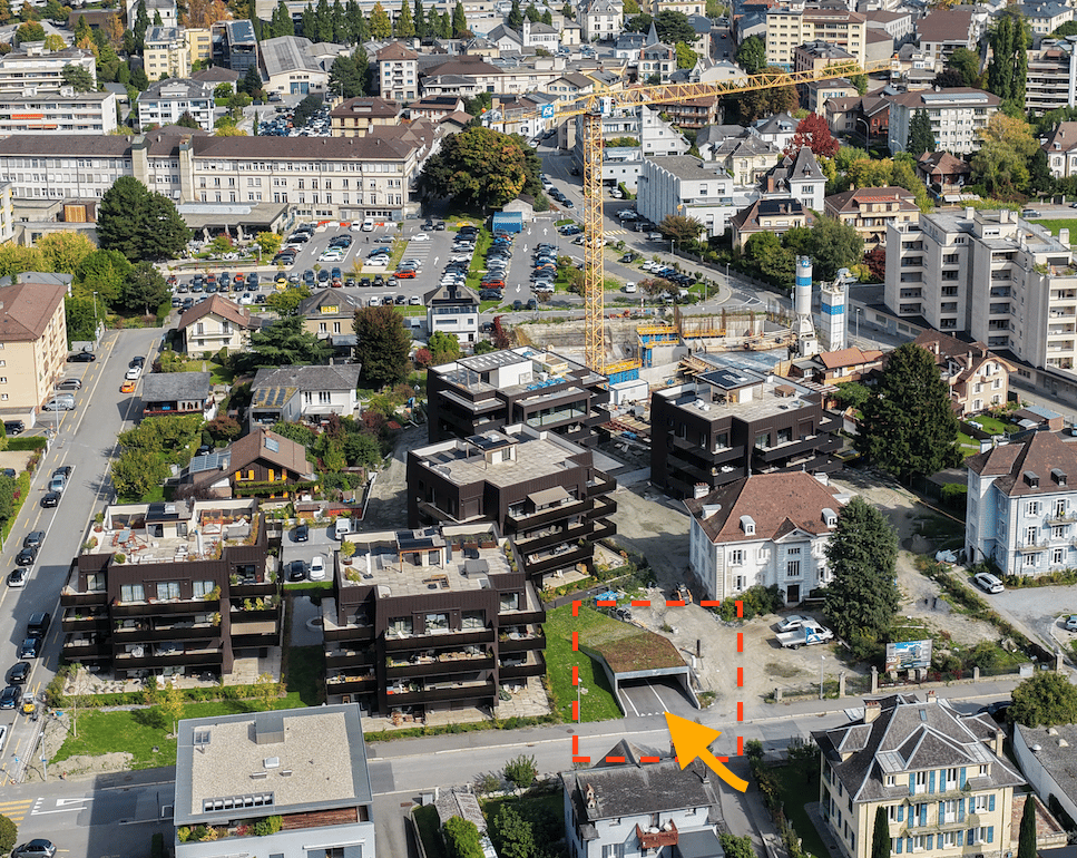 Aerial view of an urban area, residential buildings, a construction crane, and cars parked in lots