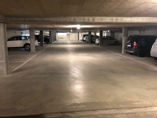 underground parking lot with several cars parked