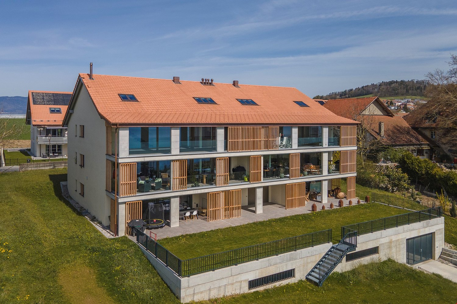 modern house, red roof, large windows, multiple balconies, raised ground floor, garden, stairs