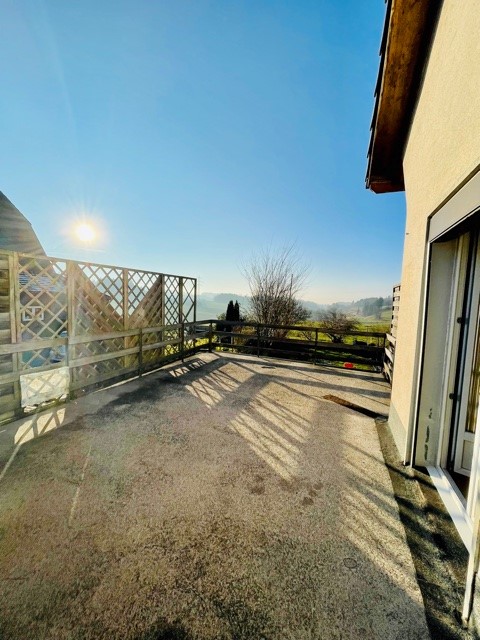 Balcony with wooden fence, gravel floor, open view of the countryside