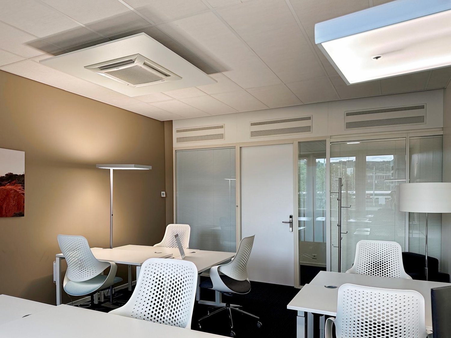 modern office with white desks, white chairs, white lamps, beige wall, glass doors, air conditioning