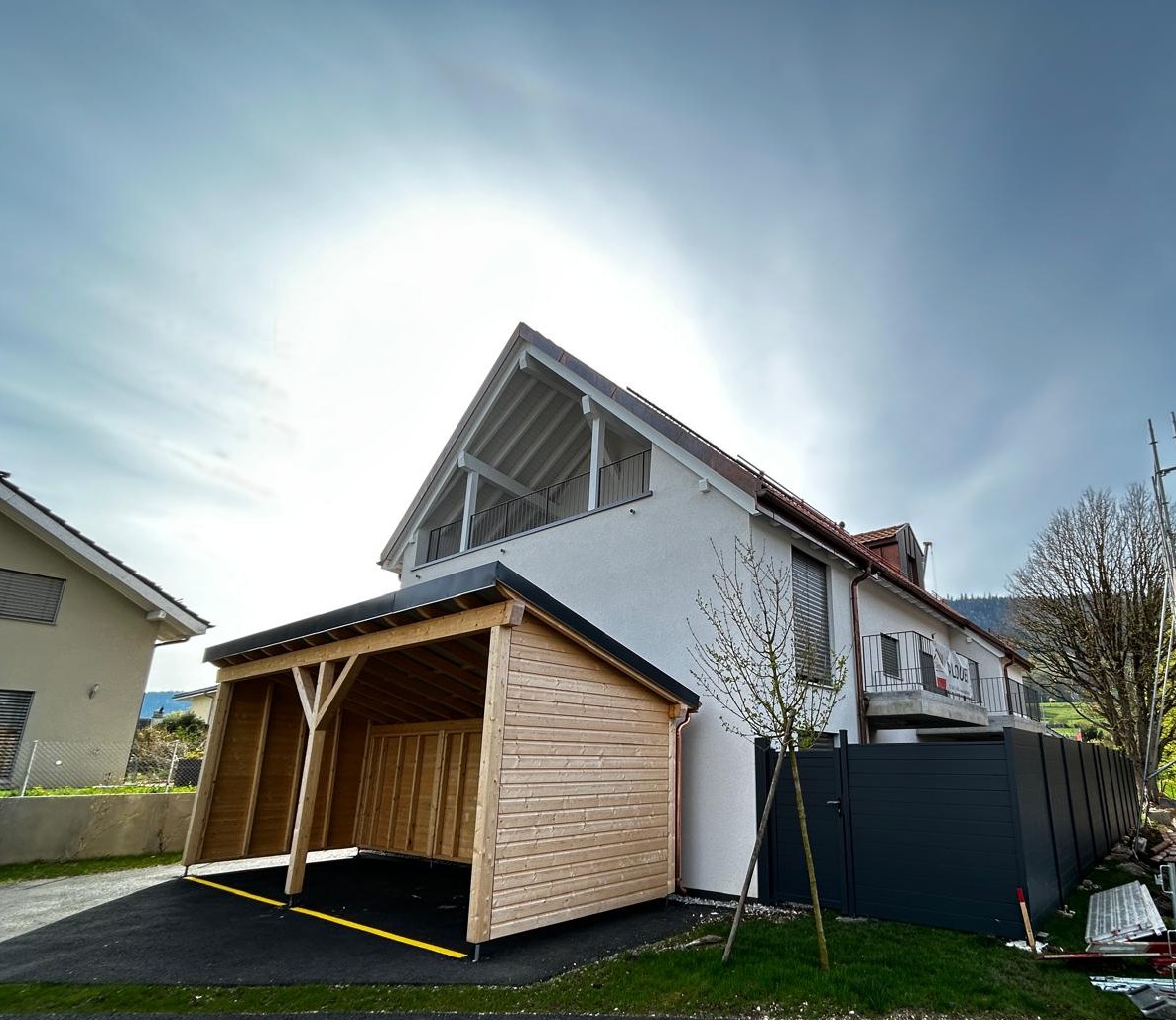 2 story house, white exterior, wooden garage, black fence, balcony