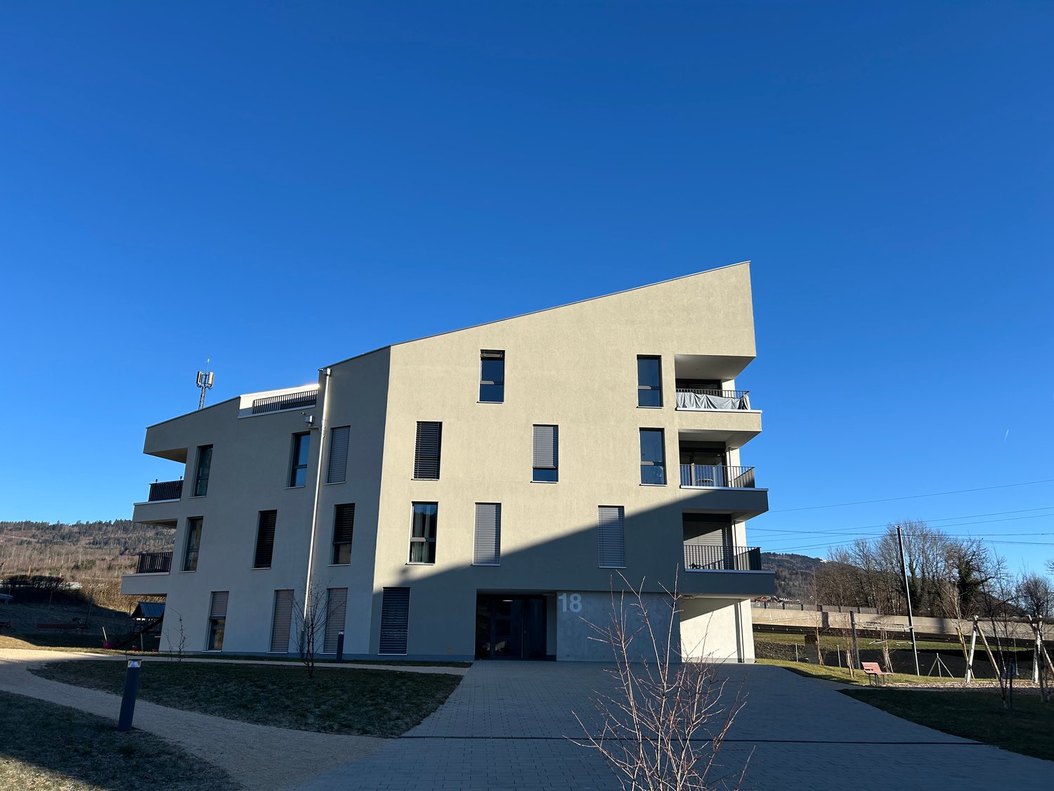 multi-story apartment building, concrete walls, glass windows, balconies