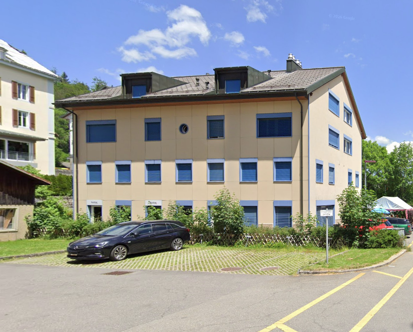 3 story building, beige exterior, blue shutters, car parked in front