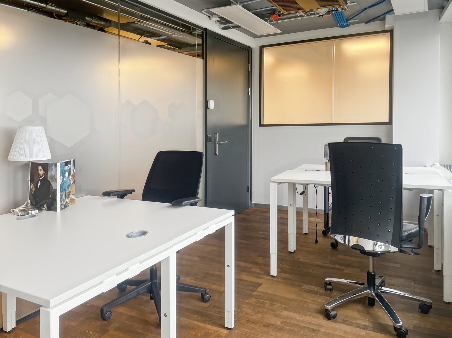 modern office, white walls, wooden floor, white desks, black chairs, glass partition, lamp, book