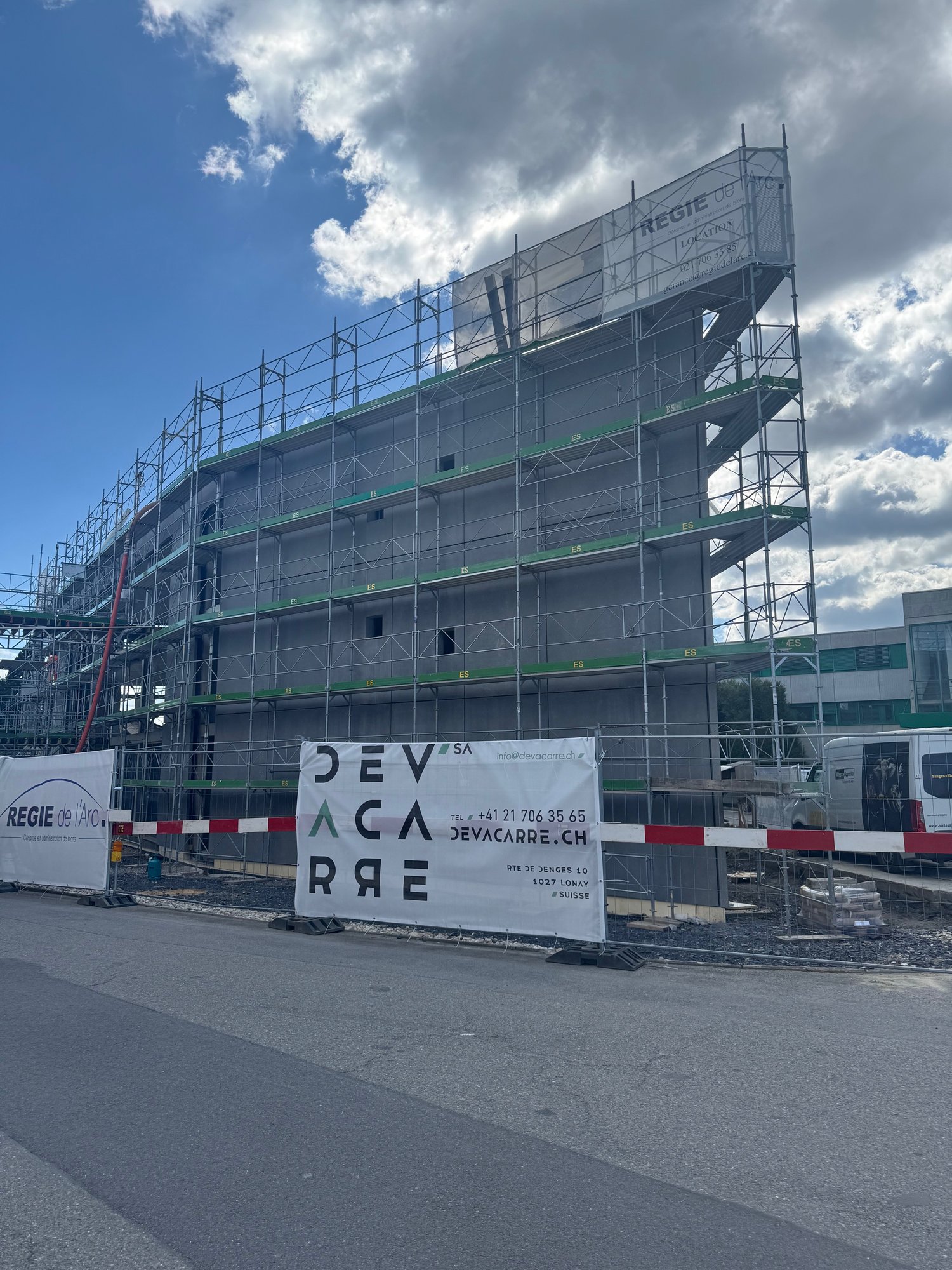 Under construction building, metal scaffolding, large banner with text