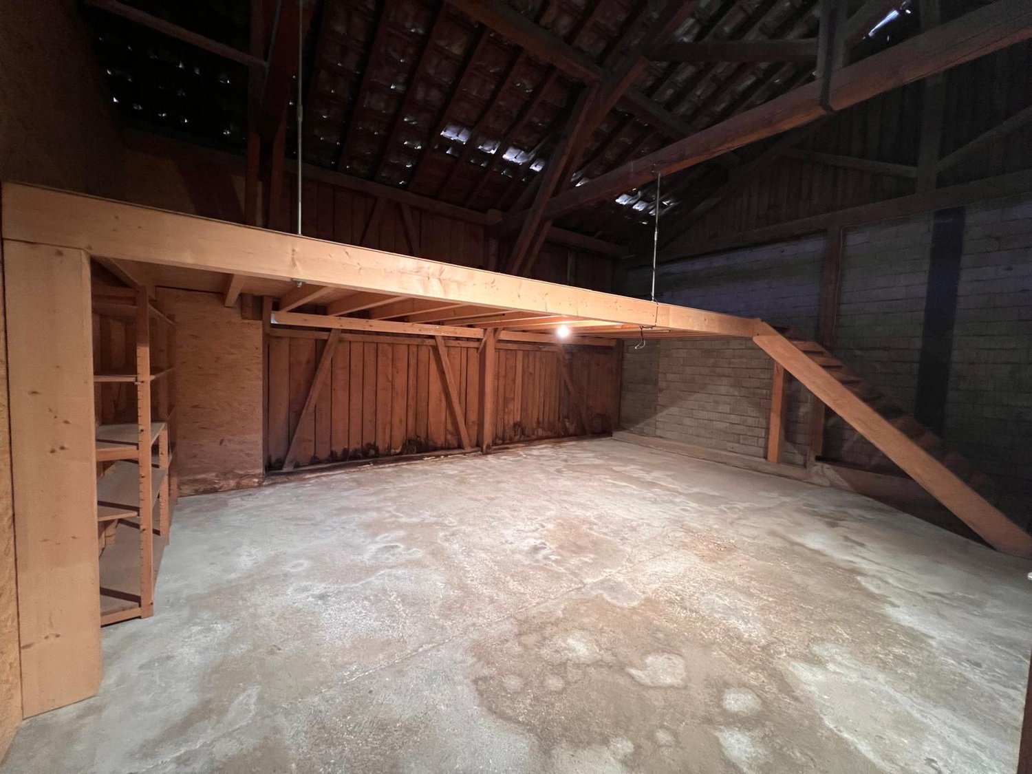 empty room, wooden beams, concrete floor, wooden shelves, wooden stairs
