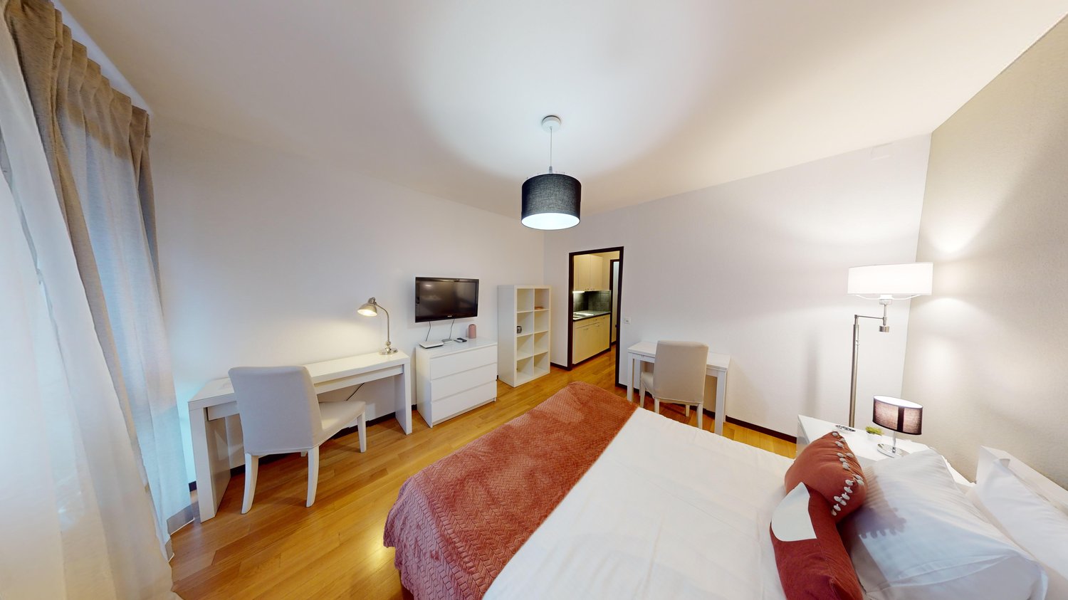 room contains a desk with chair, bed, lamp, TV and shelves