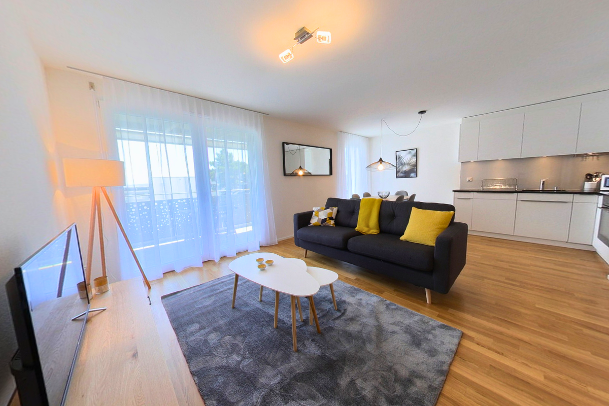 large windows, black sofa, white table, beige carpet, floor lamp, flat screen tv