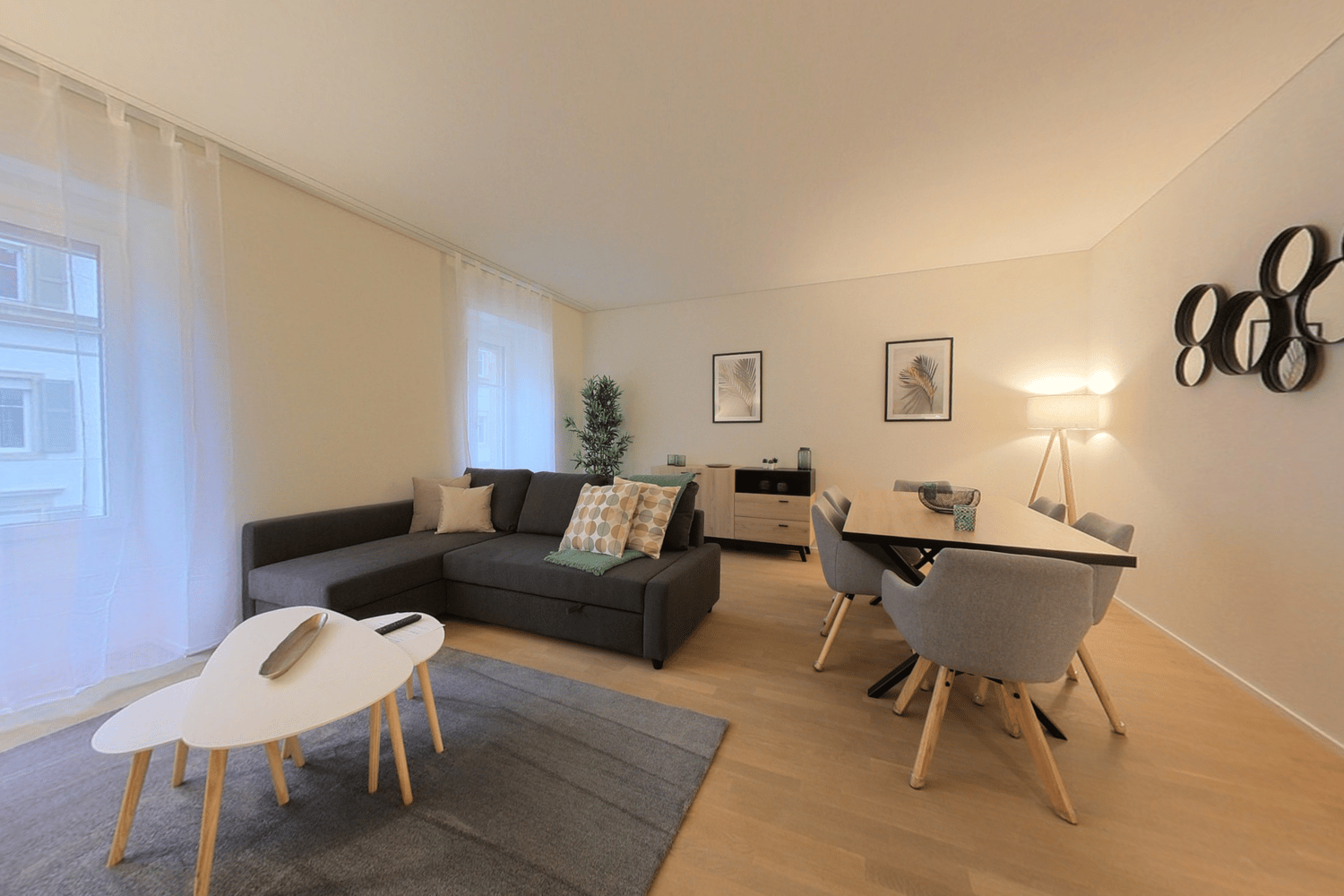 living room with couch, side table, carpet, wooden floor, windows, dining area with table and chairs