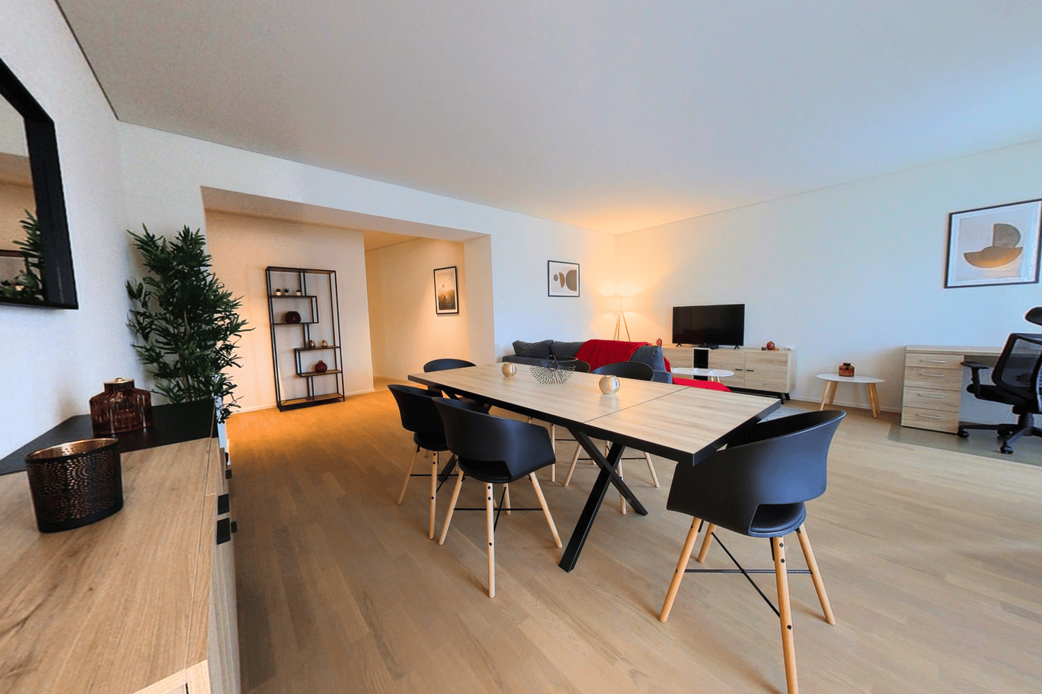 dining room with table and chairs, living room with sofa and television, floor lamp