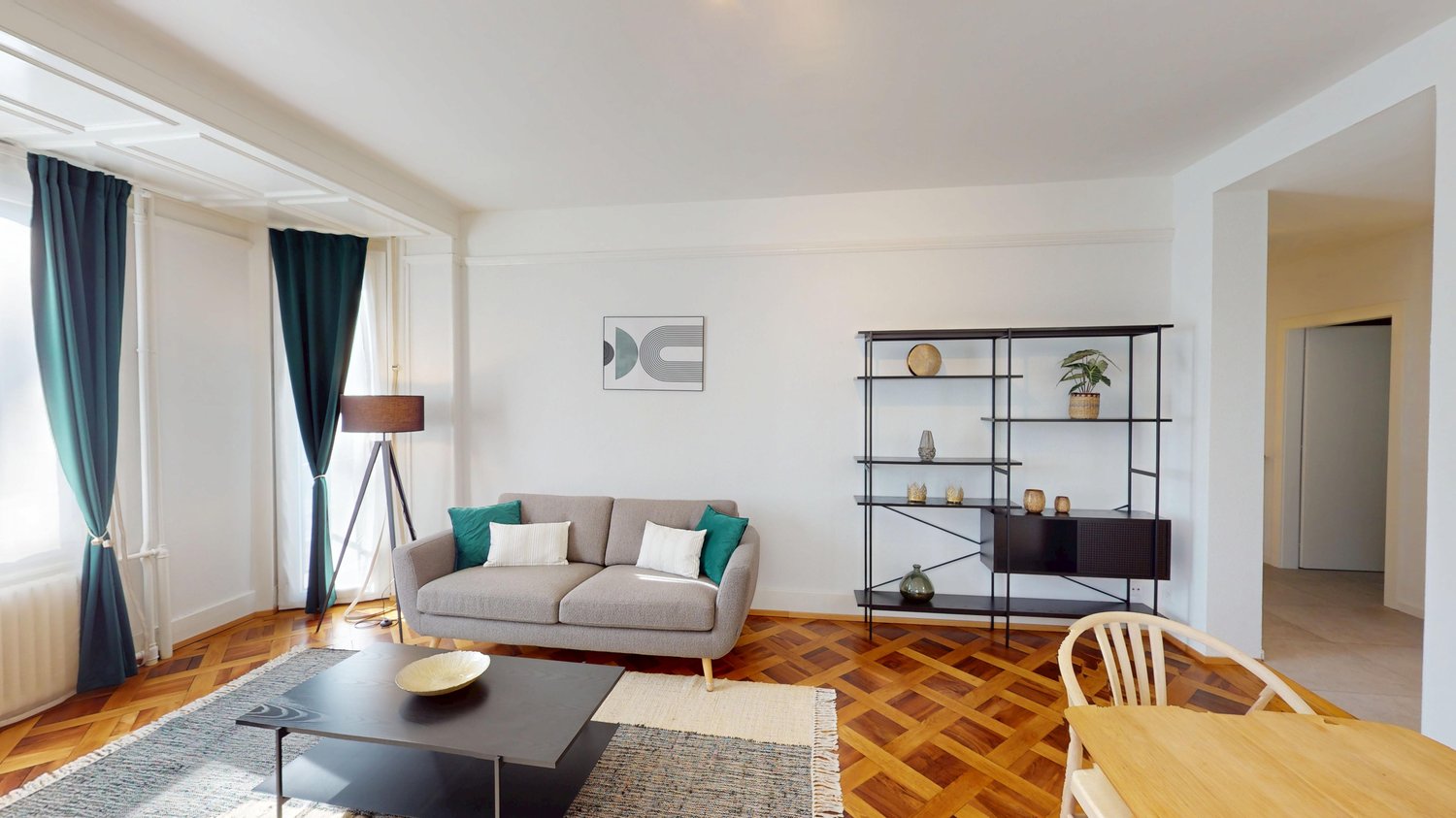 open living room, grey couch, table, wooden floor, lamps, shelves