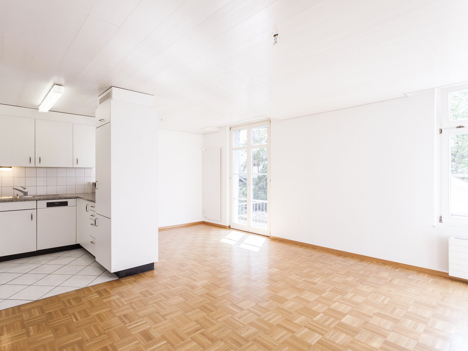 empty kitchen, white walls, wooden floor, open door, balcony