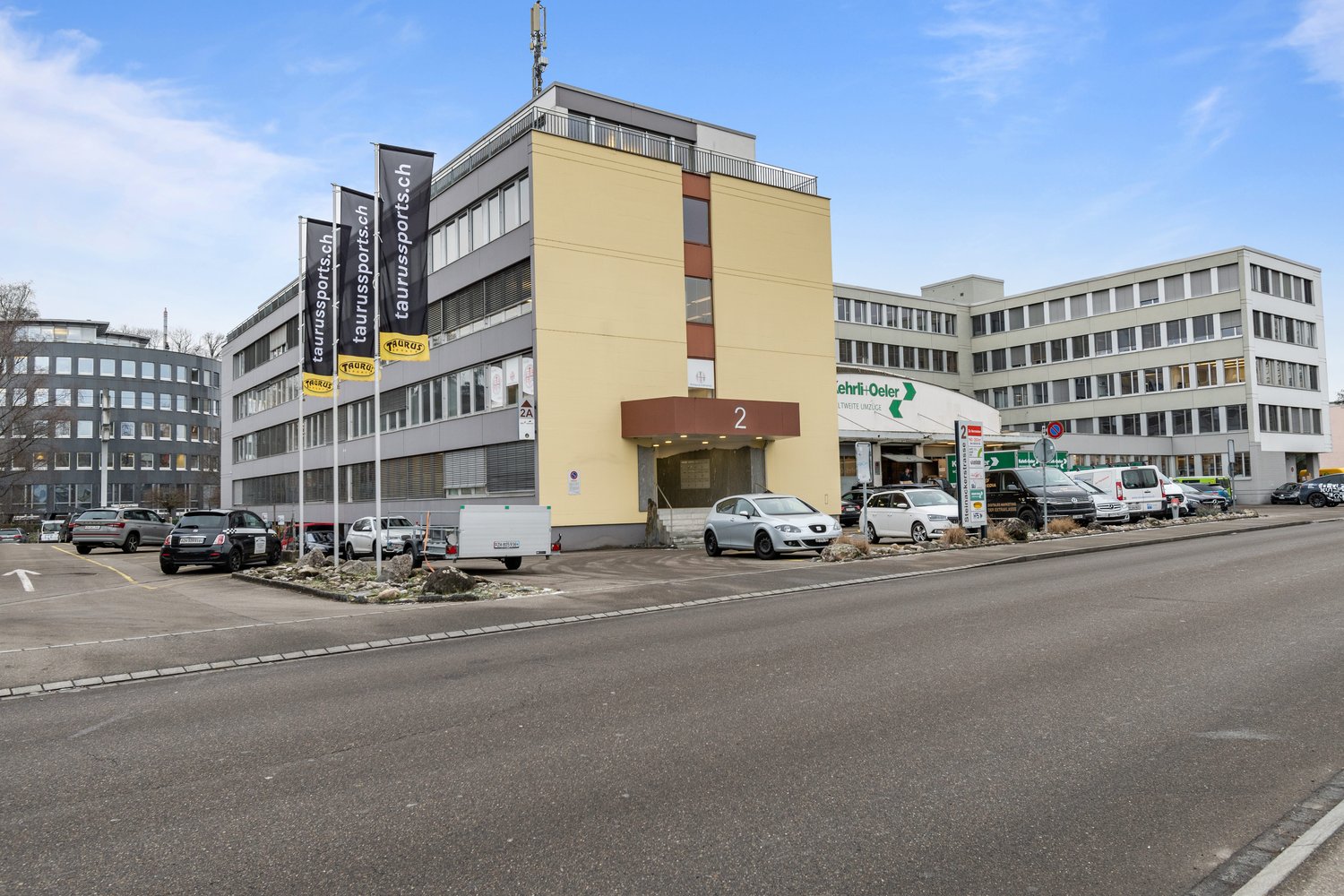 Office building with parking area, located near other buildings
