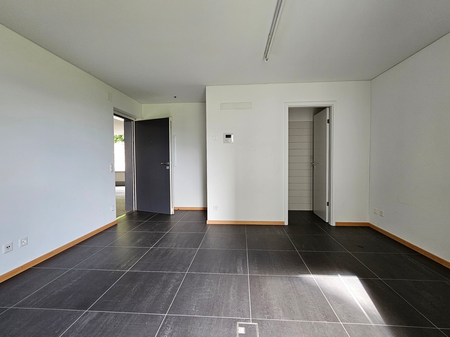 empty room, white walls, tiled floor, power outlets, doorways