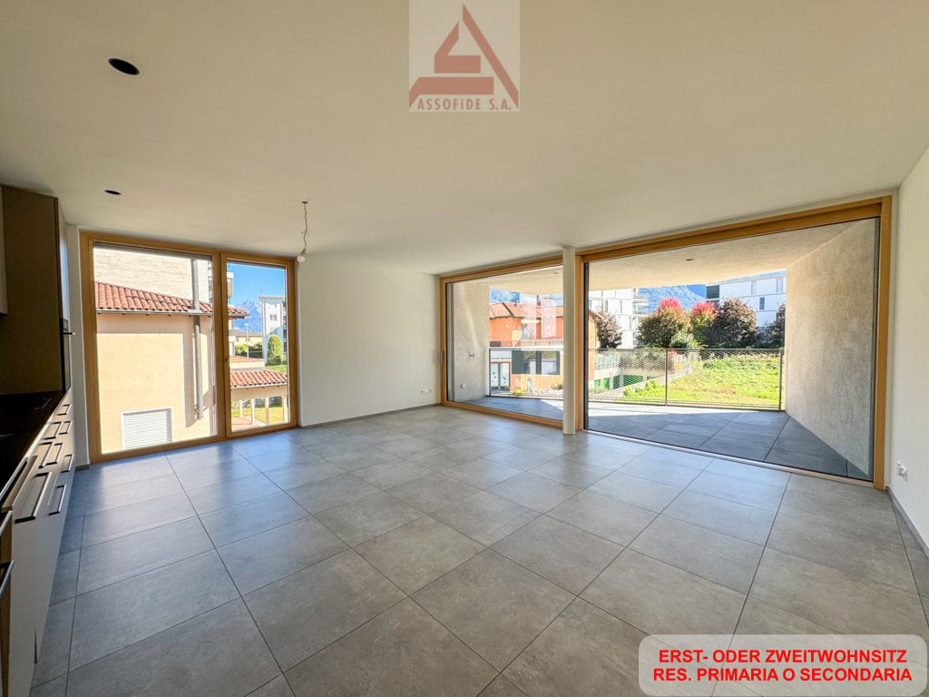 large room, gray tile floor, sliding glass doors leading to a balcony