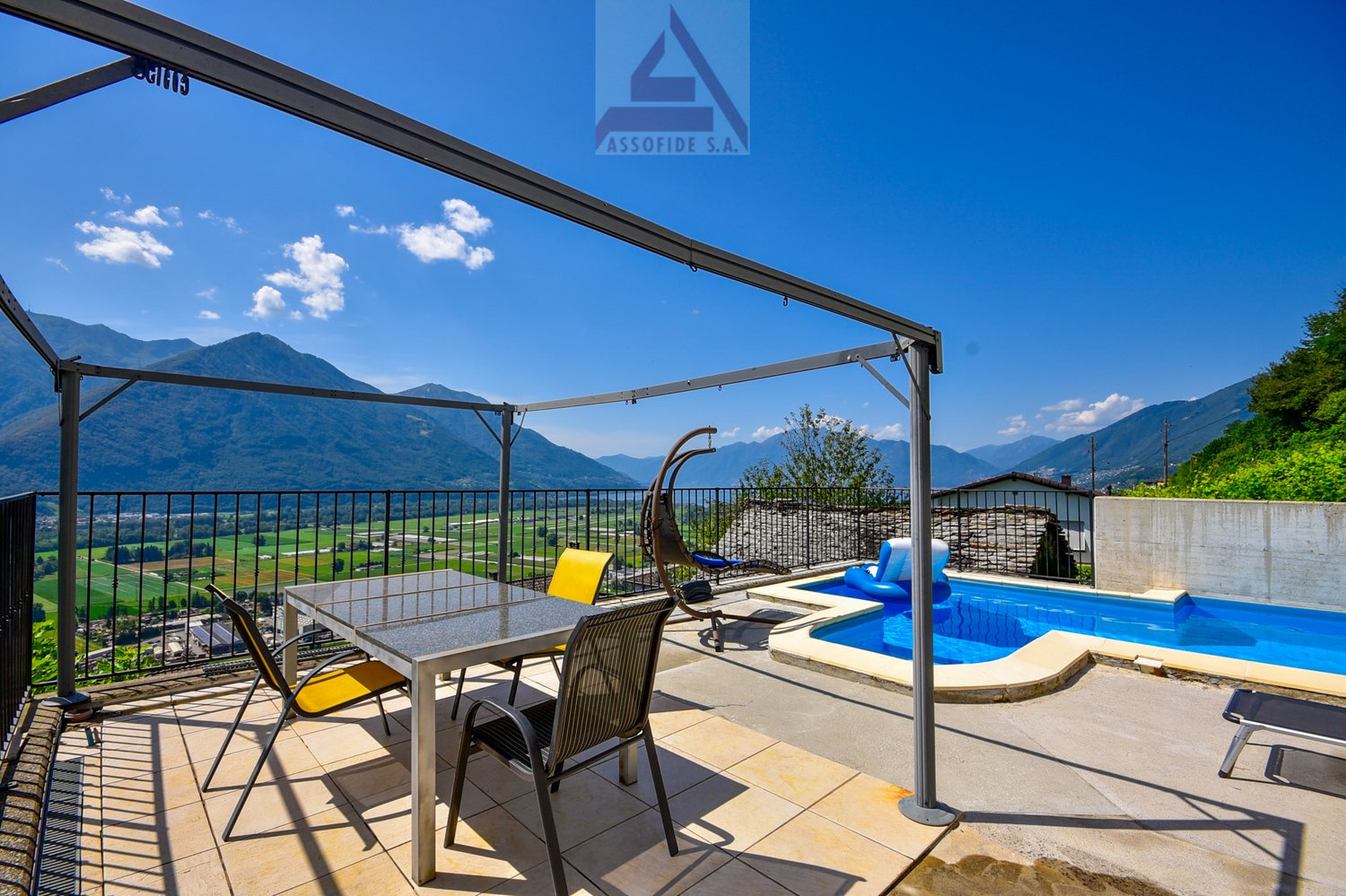 Balcony with pool, metal pergola, table, chairs, swings, view of mountains
