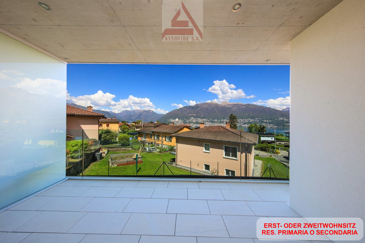 large glass wall, balcony, tiled floor, view of mountains and houses
