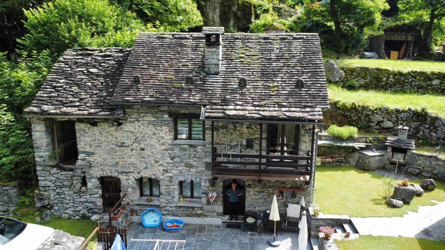 Stone house, wooden door, balcony, garden, green surroundings