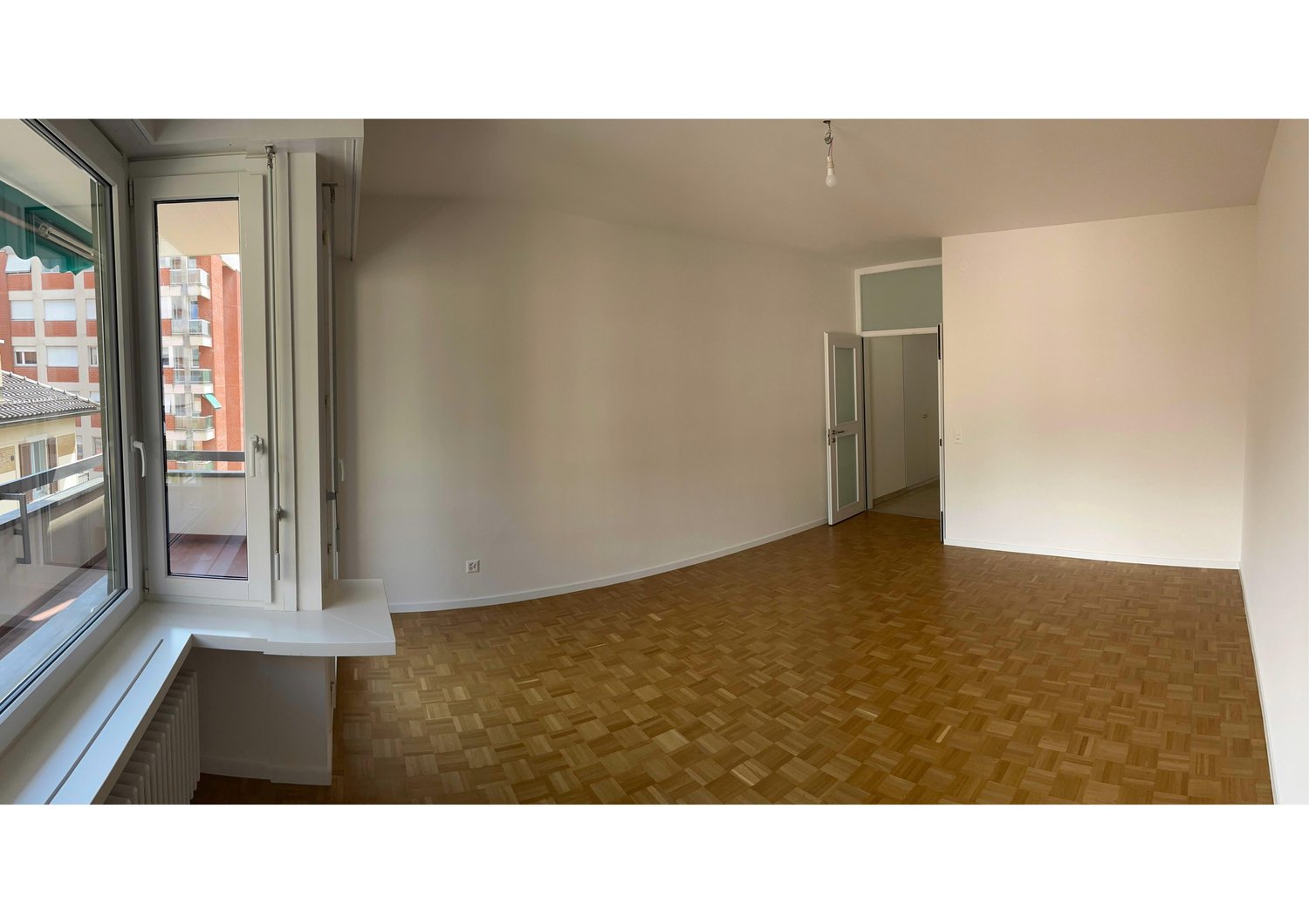 empty room, wooden floor, white walls, large windows, balcony, radiator