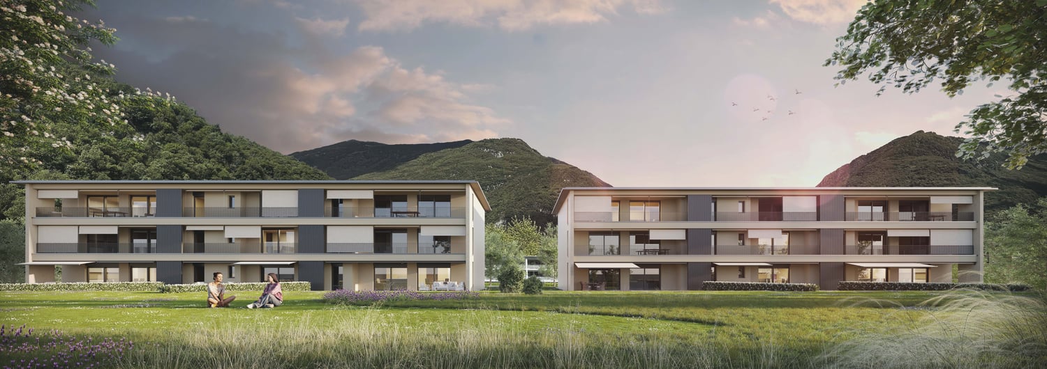 Two story apartment buildings, gray and white walls, balconies, windows, raised ground floor, garden in front, mountains in background