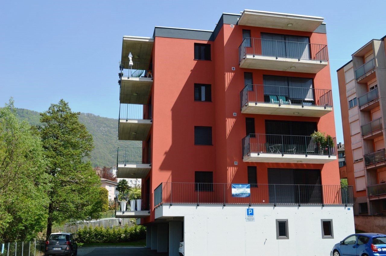 apartment building, red brick, multiple balconies, private parking