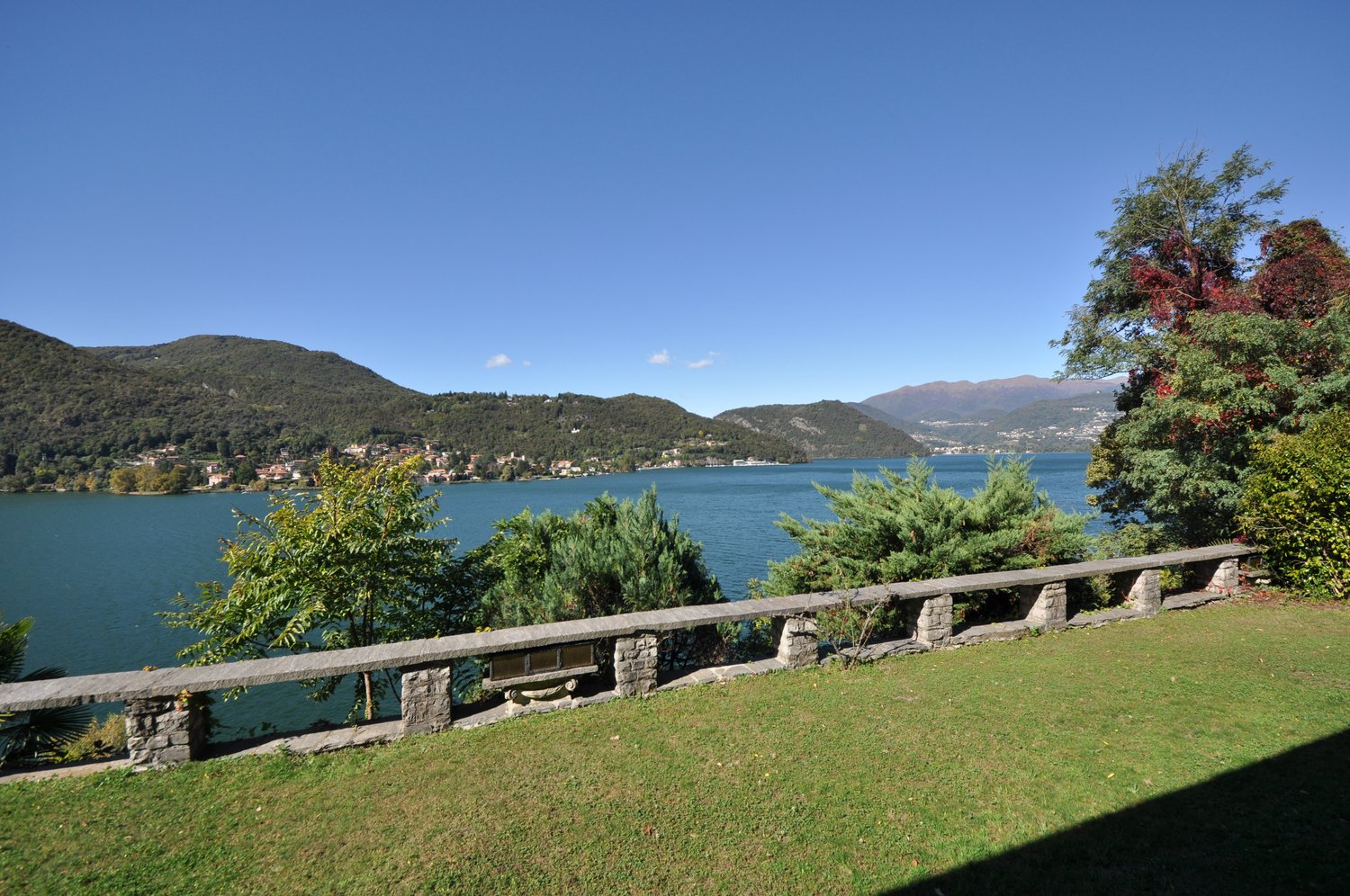Green lawn, lake in background, mountains