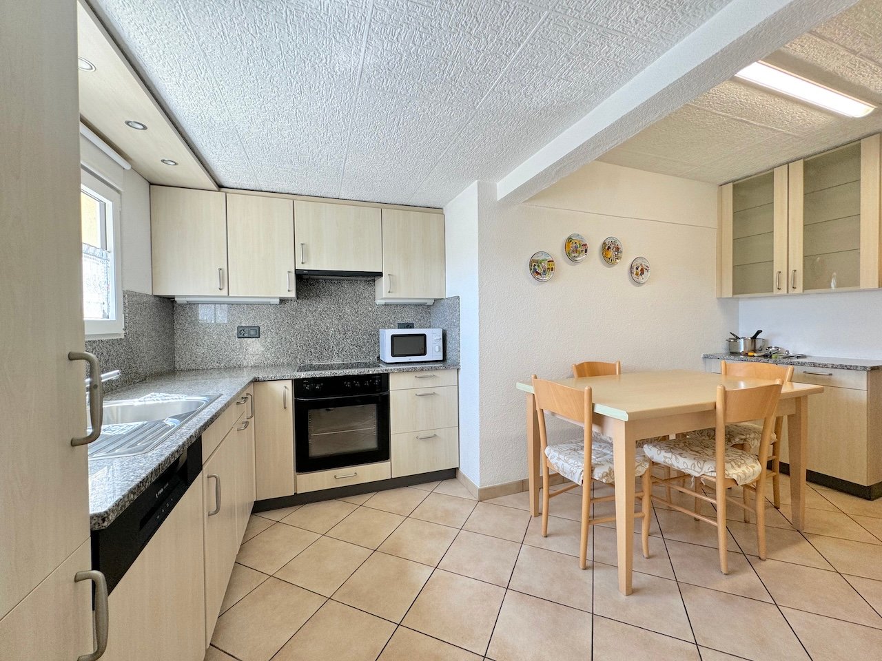 wooden cabinets, granite countertops, built-in microwave, electric oven, dishwasher, dining table, chairs, sink, faucet