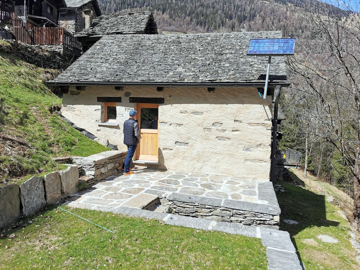 Single story stone house, elevated, solar panel on roof