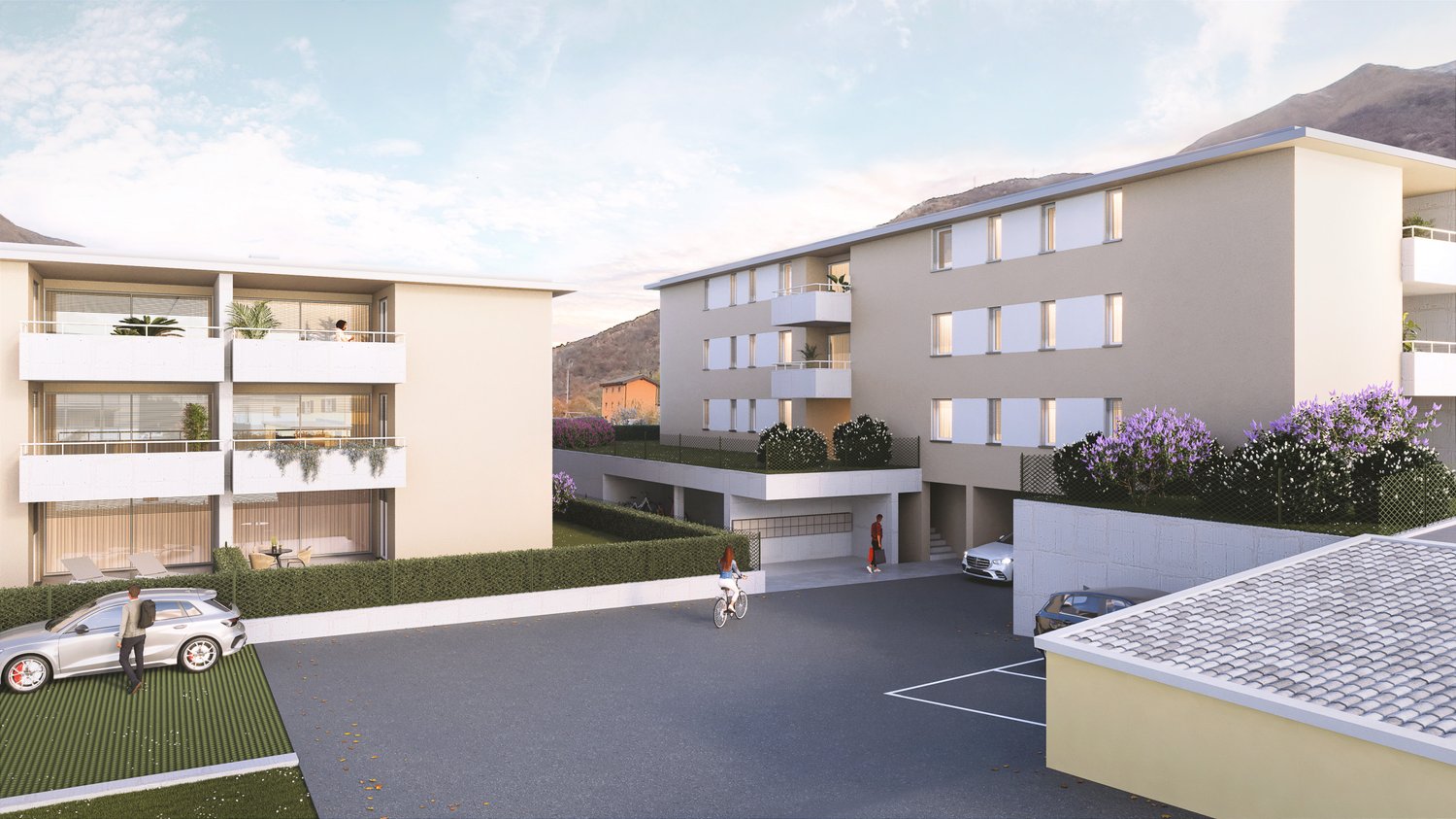 Two-story apartment building, beige exterior, multiple balconies, parking area, greenery