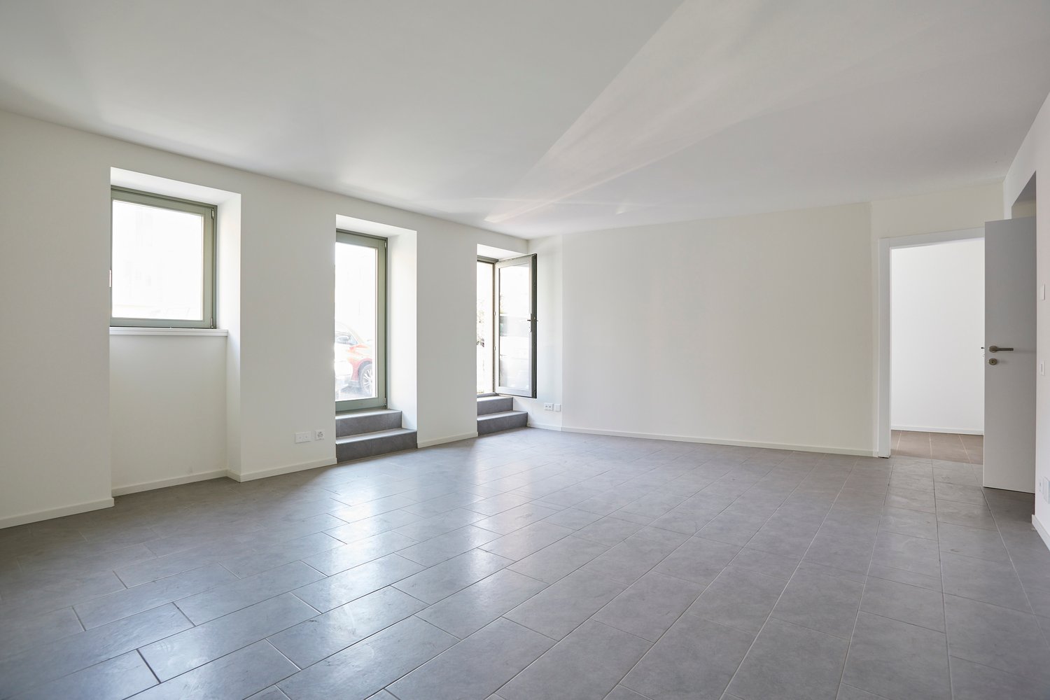 Empty room, tile floor, 2 windows, doorways