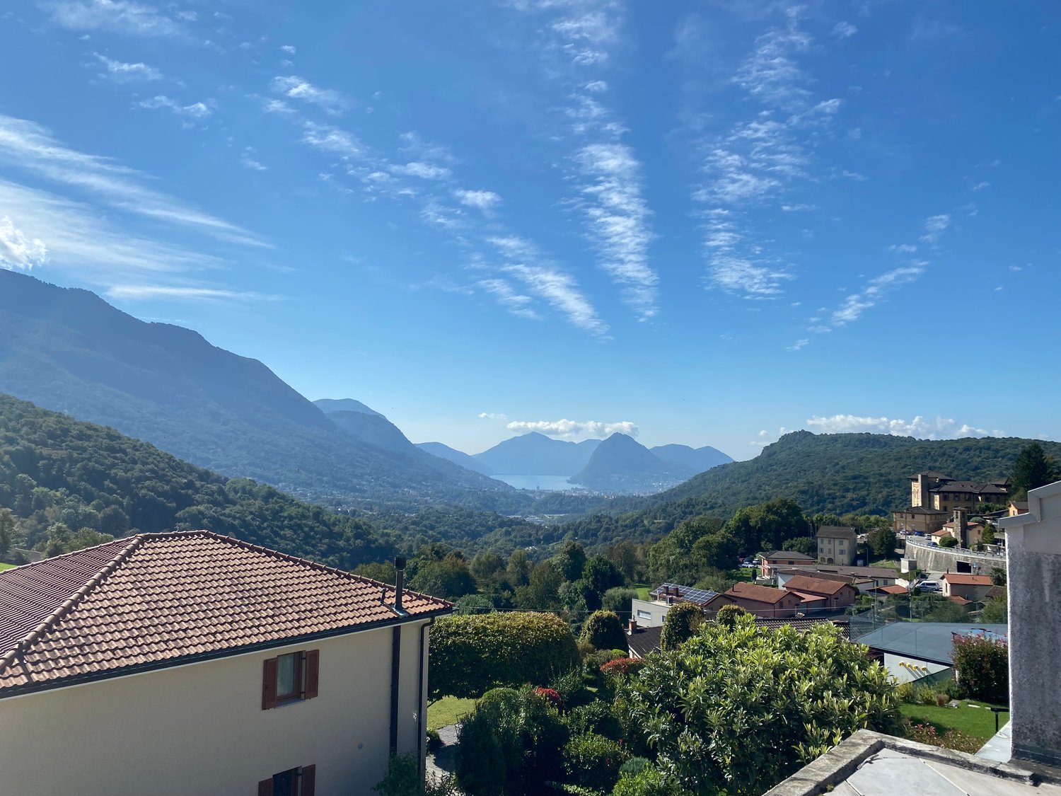 hilltop view of mountains and a lake in the distance