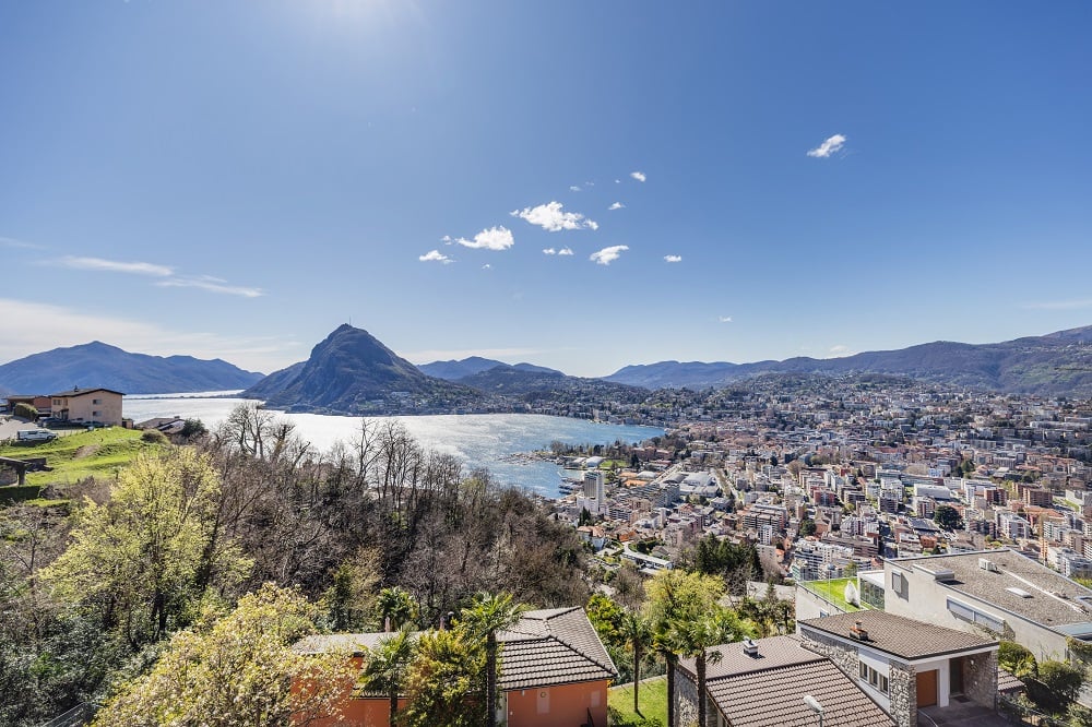 Houses on a hill with a view of the city and mountains