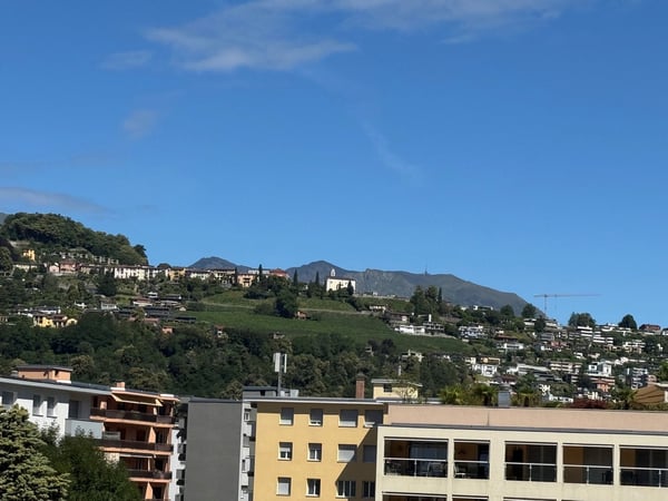 3.5 locali con vista aperta sulla città e montagne e due posti auto 3