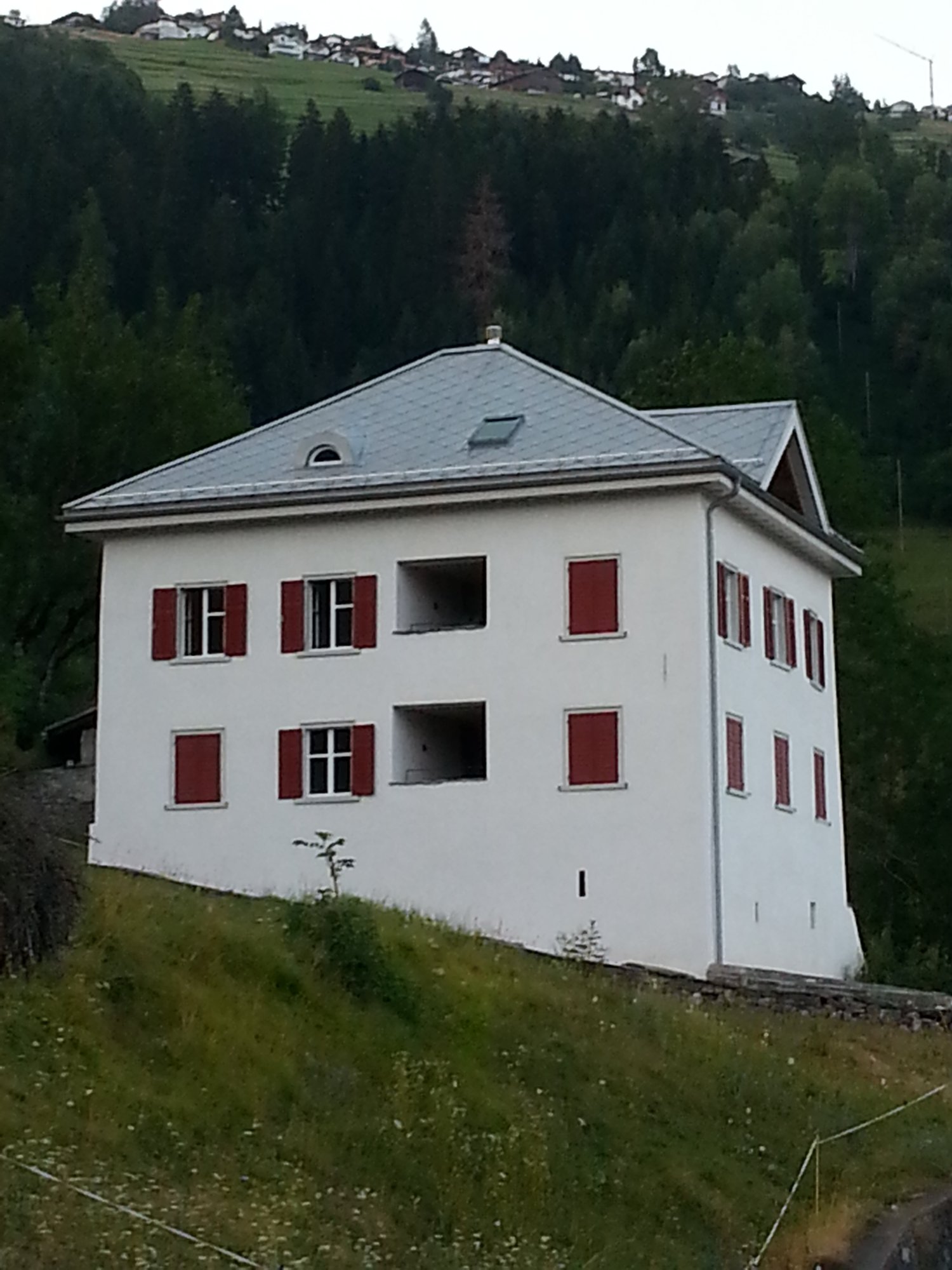 white house, red shutters, gray roof, on a hill, surrounded by trees