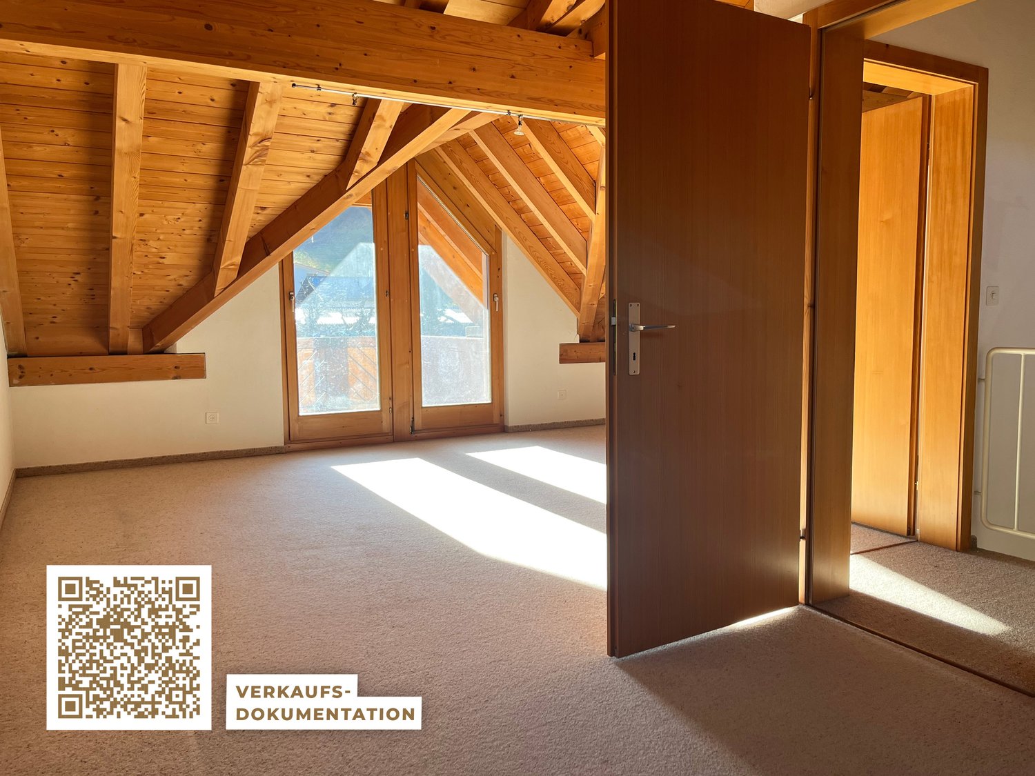 empty attic room with wooden ceiling, carpeted floor, large windows, open door