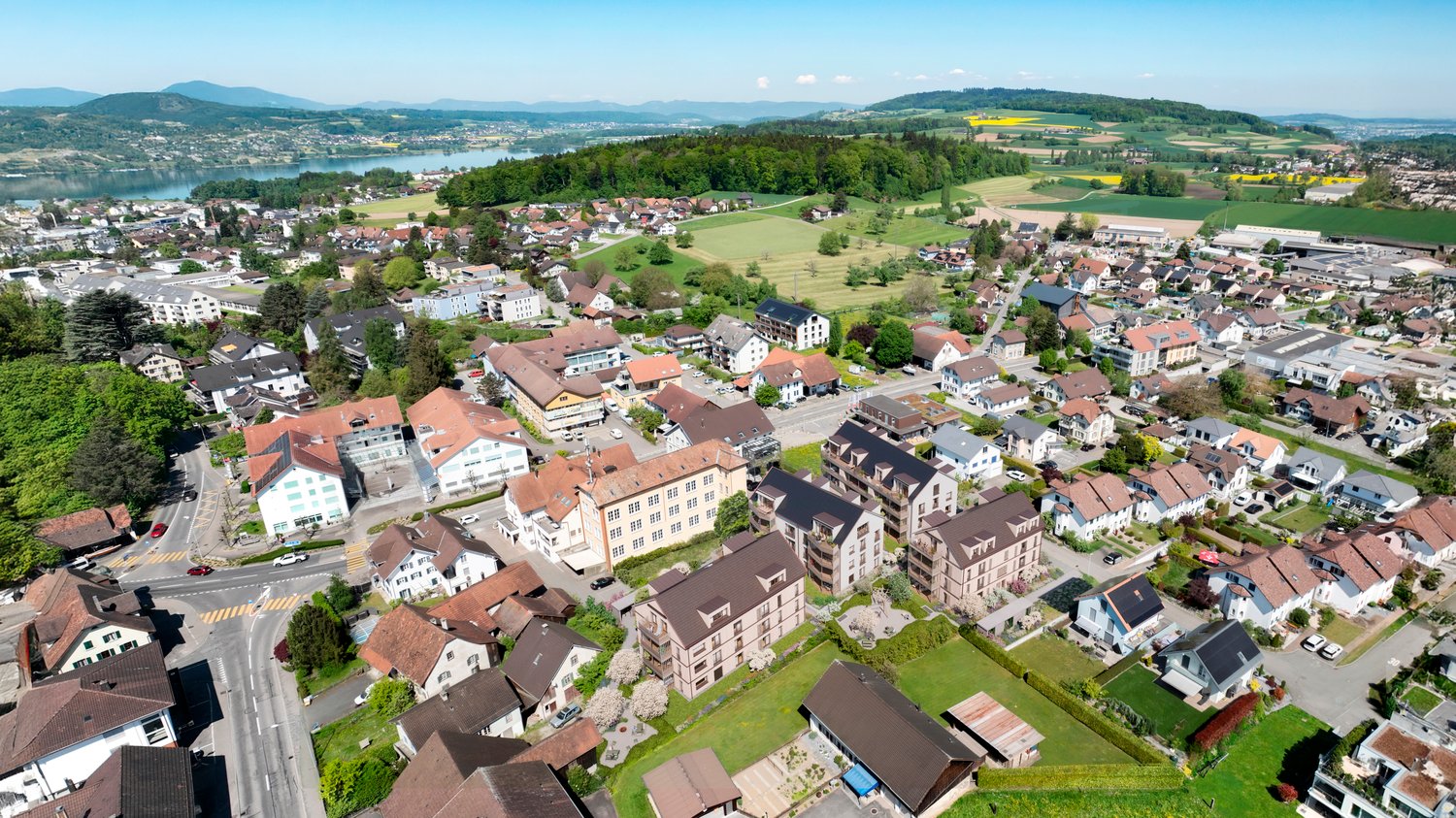 apartment building with balconies, surrounded by greenery