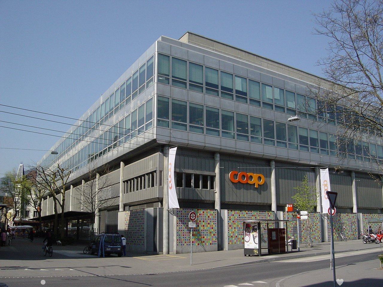 modern office building with large windows, COOP banner on the front, colorful murals on the walls