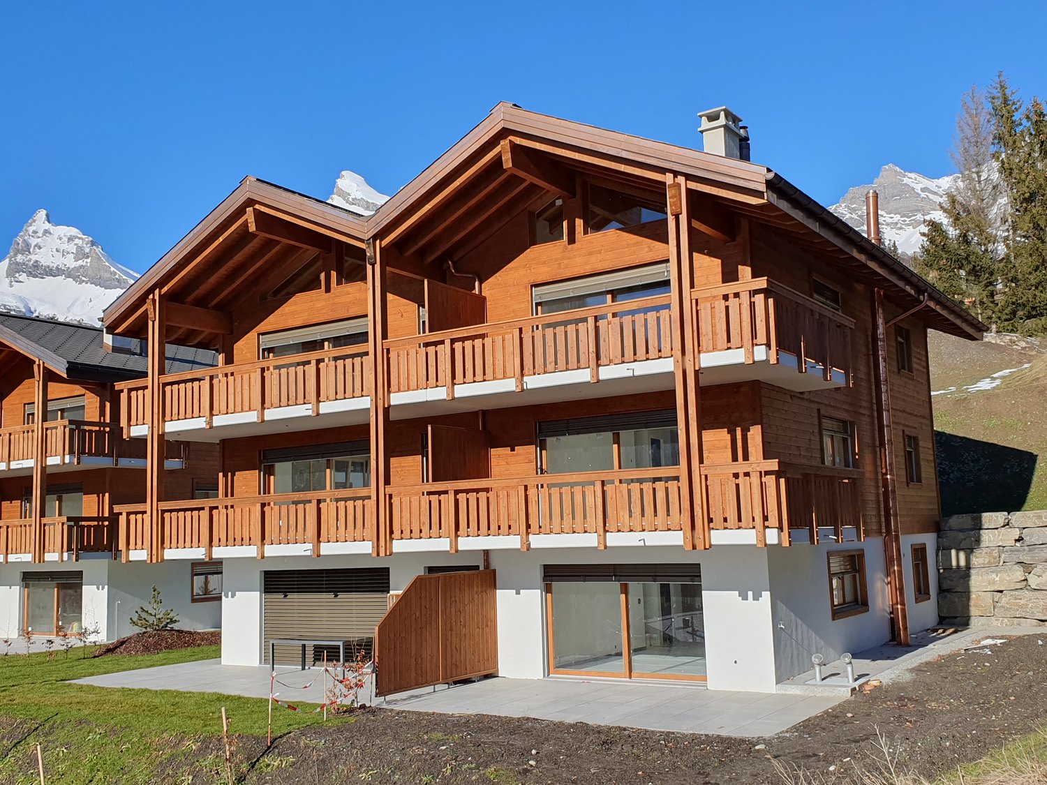3 story wooden chalet, balconies on all levels, glass entrance doors, underground garage