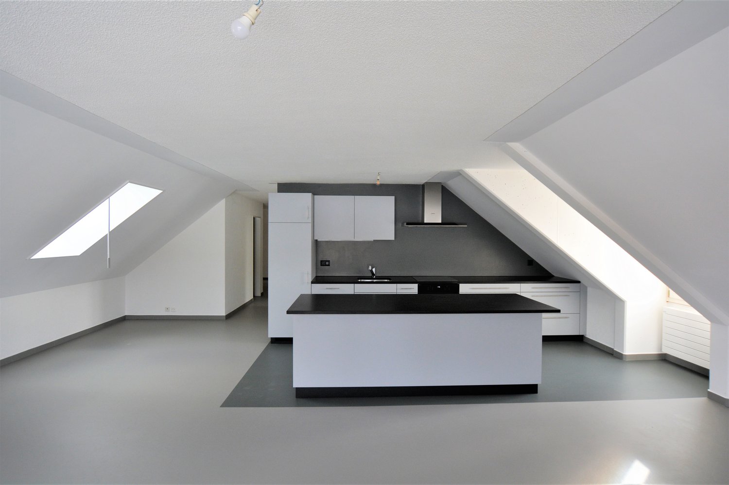 Empty kitchen with countertop, cabinets, sink, stove, and skylights