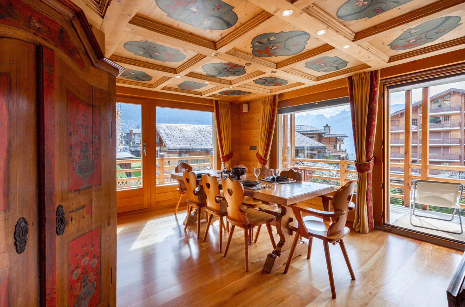 Dining table, wooden chairs, large windows, balcony with table and chair, wooden flooring, decorative ceiling