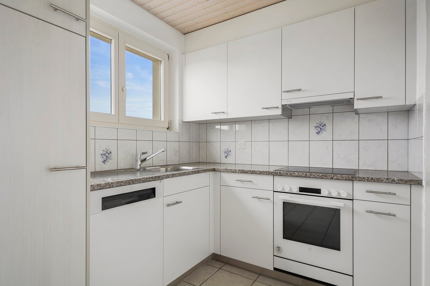 modern kitchen with a white finish, granite countertops, white cabinets, and blue ceramic tiles. A dishwasher is installed below the countertop, a sink and faucet are located above it, and an oven is positioned next to the countertop.