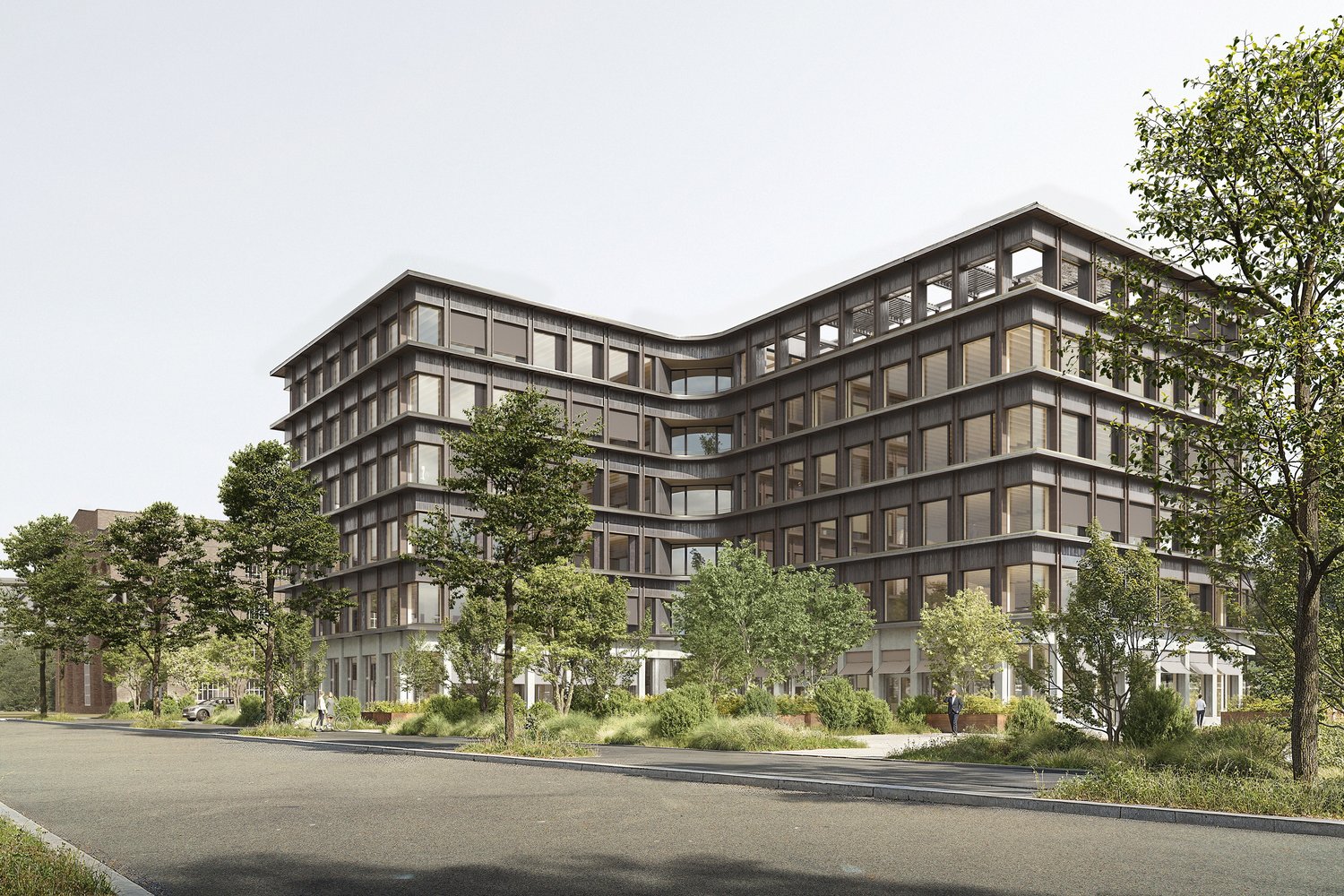 Multi-story office building with glass and steel facade, surrounded by trees and landscaping, with a parking area in the foreground